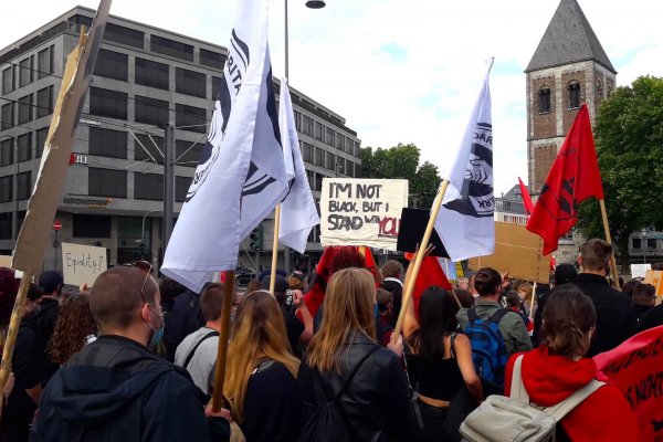 Solidaritätsnetzwerk Deutschland organisiert eine Demo zum Thema „Black lives matter“ - Demonstrierenden halten Plakate und Fahnen hoch