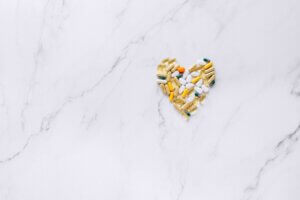 Medikamente finden - ein Herz aus Tabletten liegt auf marmoriertem Hintergrund