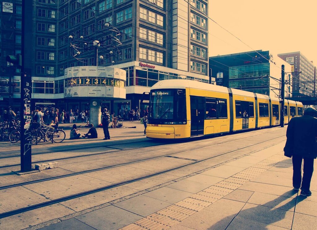Zu sehen ist eine Tram sowie die Weltzeituhr am Berliner Alexanderplatz