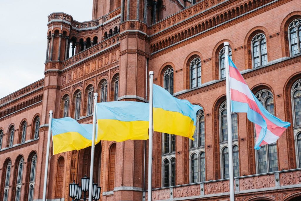 Zus ehen sind die Ukraineflagge und Transgenderflagge am roten Rathaus in Berlin